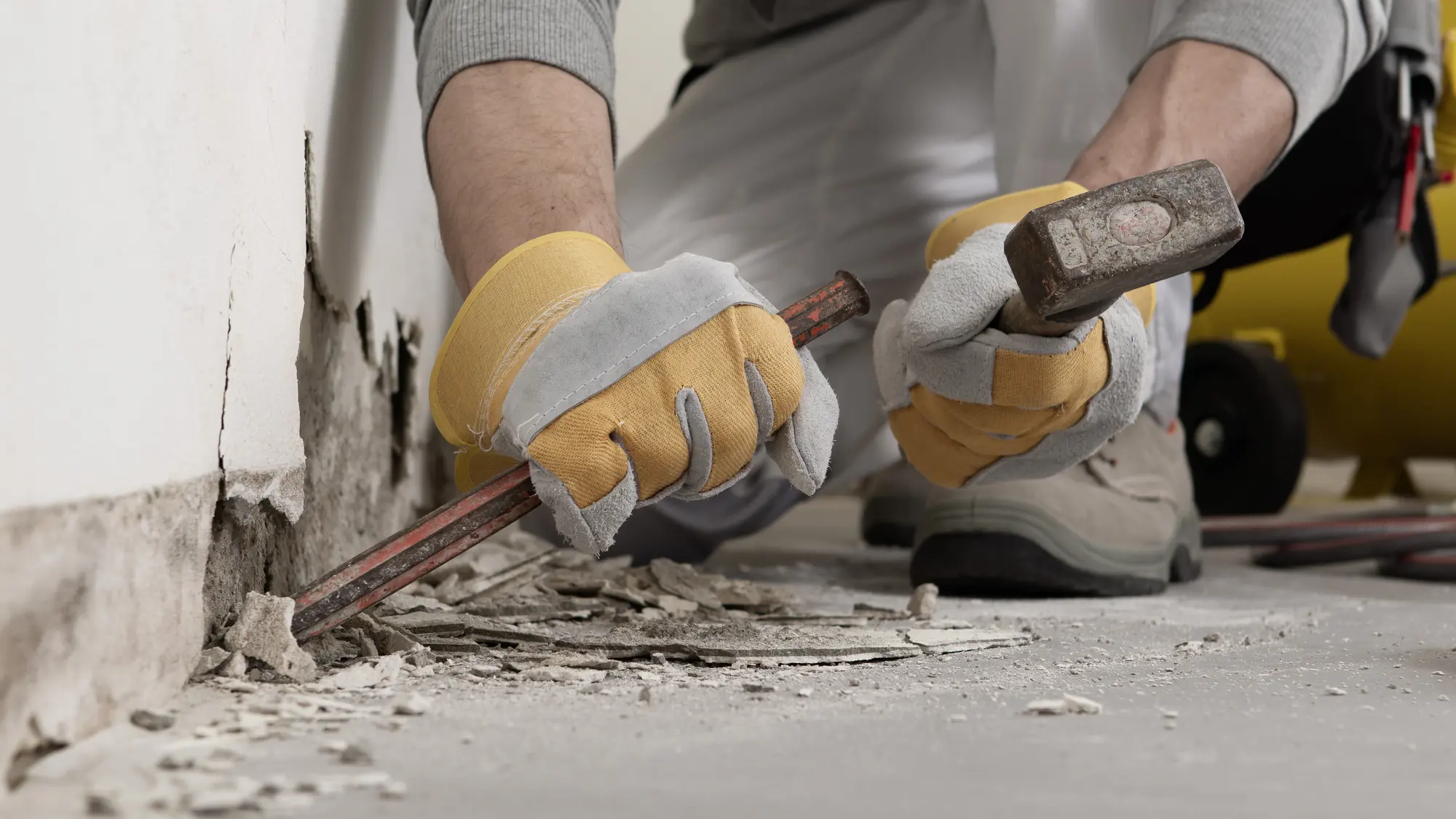 Stemmarbeiten an einer Wand mit Hammer und Meißel